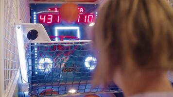 Teenage boy playing arcade basketball video