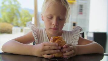 contemplativo menina sentado com pastelaria dentro cafeteria video