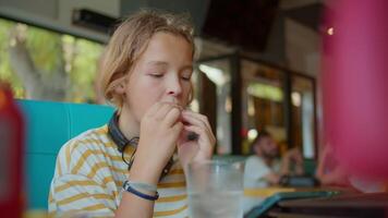 Boy enjoying hotdog and smartphone video