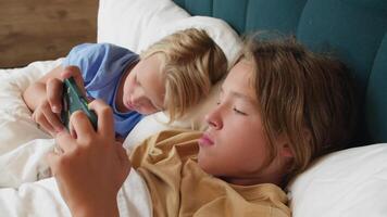 Kinder spielen mit Smartphone im Bett video