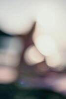 Abstract defocused silhoute of middle aged well looking woman with black hair doing Pilates with the ring on the yoga mat near the sea on the pebble beach. Female fitness yoga concept. photo