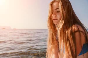 Woman sea sup. Close up portrait of happy young caucasian woman with long hair looking at camera and smiling. Cute woman portrait in a blue bikini posing on sup board in the sea photo