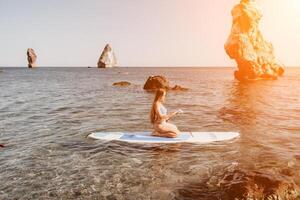 mujer mar sorber. cerca arriba retrato de contento joven caucásico mujer con largo pelo mirando a cámara y sonriente. linda mujer retrato en un azul bikini posando en cenar tablero en el mar foto