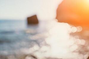 resumen naturaleza verano Oceano puesta de sol mar antecedentes. pequeño olas en agua superficie en movimiento difuminar con bokeh luces desde amanecer. día festivo, vacaciones y recreativo antecedentes concepto. foto