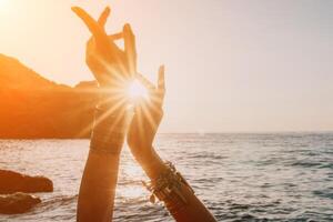 mujer mar yoga. contento mujer en blanco traje de baño y boho estilo pulseras practicando al aire libre en yoga estera por mar en puesta de sol. mujer yoga aptitud rutina. sano estilo de vida, armonía y meditación foto