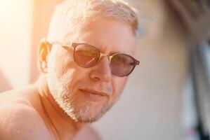 Outdoor portrait of mid aged happy caucasian man in sunglasses l photo