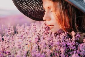 mujer lavanda campo. contento despreocupado mujer en negro vestir y sombrero con grande borde oliendo un floreciente lavanda en puesta de sol. Perfecto para inspirador y calentar conceptos en viaje y pasión de viajar. cerca arriba foto