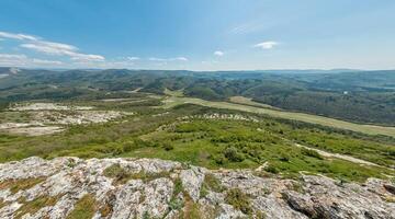 Wide panoramic view on mountain landscape with lush green hills under clear blue sky, tranquil natural beauty, perfect for outdoor enthusiasts. photo