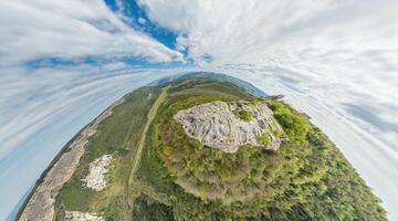 amplio panorámico ver en montaña paisaje con lozano verde colinas debajo claro azul cielo, tranquilo natural belleza, Perfecto para al aire libre entusiastas pequeño planeta 360 panorama foto