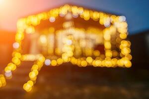 Abstract defocused bright Christmas lights on wooden house, creating decorative illumination in evening scene photo