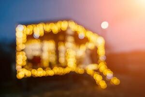 Abstract defocused bright Christmas lights on wooden house, creating decorative illumination in evening scene photo