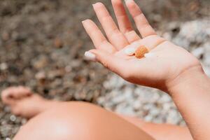 Woman eating milky almond nuts. A young caucasian woman chopping fresh green almond after morning fitness yoga near sea. Only hands are visibly. Healthy vegan food. Slow motion. Close up photo