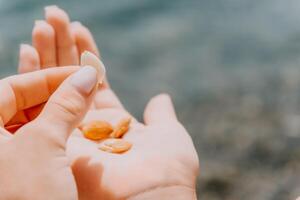 Woman eating milky almond nuts. A young caucasian woman chopping fresh green almond after morning fitness yoga near sea. Only hands are visibly. Healthy vegan food. Slow motion. Close up photo