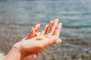 Woman eating milky almond nuts. A young caucasian woman chopping fresh green almond after morning fitness yoga near sea. Only hands are visibly. Healthy vegan food. Slow motion. Close up photo