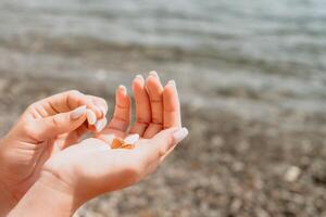 Woman eating milky almond nuts. A young caucasian woman chopping fresh green almond after morning fitness yoga near sea. Only hands are visibly. Healthy vegan food. Slow motion. Close up photo