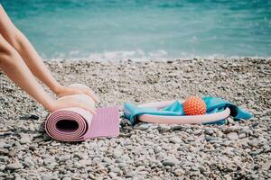 Pilates magic ring and rubber band on yoga mat near sea. Female fitness yoga concept. Healthy lifestyle harmony and meditation. photo