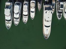 Aerial panoramic view of Balaklava landscape with boats and sea in marina bay. Crimea Sevastopol tourist attraction. Drone top view shot of port for luxury yachts, boats and sailboats. photo