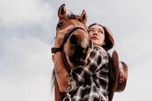 joven contento mujer en sombrero con su caballo en noche puesta de sol ligero. al aire libre fotografía con Moda modelo muchacha. estilo de vida humor. concepto de al aire libre equitación, Deportes y recreación. foto