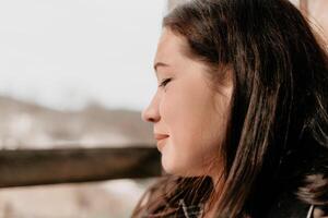 contento joven sonriente mujer con pecas al aire libre retrato. suave soleado colores. al aire libre de cerca retrato de un joven morena mujer y mirando a el cámara, posando en contra otoño naturaleza antecedentes foto