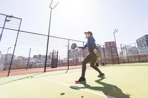 mujer jugando paleta tenis al aire libre. foto