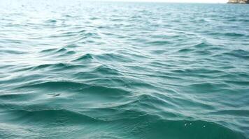 mare acqua superficie. telecamera mosche al di sopra di il calma azzurro mare. nessuno. vacanza ricreazione concetto. astratto nautico estate oceano natura. tempo metereologico e clima modificare. lento movimento. vicino su video