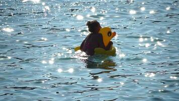 Summer Vacation Woman floats on an inflatable donut mattress, a water toy swim ring. Positive happy woman relaxing and enjoying family summer travel holidays vacation on the sea. Slow motion video