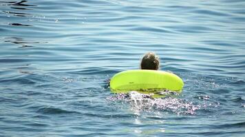 Sommer- Ferien Frau schwimmt auf ein aufblasbar Krapfen Matratze, ein Wasser Spielzeug schwimmen Ring. positiv glücklich Frau entspannend und genießen Familie Sommer- Reise Ferien Ferien auf das Meer. schleppend Bewegung video
