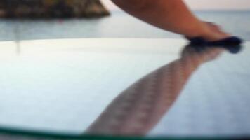 Young lady clean table in tropical beach cafe bar restaurant of hotel or resort with Defocused sea on hot summer day. Holiday, vacation and recreation. video