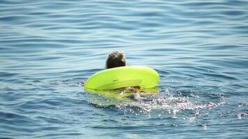 Summer Vacation Woman floats on an inflatable donut mattress, a water toy swim ring. Positive happy woman relaxing and enjoying family summer travel holidays vacation on the sea. Slow motion video