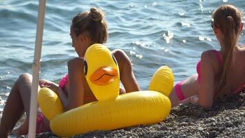 verano vacaciones mujer flotadores en un inflable rosquilla colchón, un agua juguete nadar anillo. positivo contento mujer relajante y disfrutando familia verano viaje Días festivos vacaciones en el mar. lento movimiento video