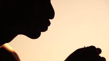 Silhouette of a man enjoying a hamburger. Side view portrait of a person savoring a delicious, satisfying burger with great appetite. Fast food indulgence. video