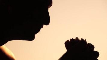 silhouette di un' uomo godendo un' Hamburger. lato Visualizza ritratto di un' persona assaporando un' delizioso, soddisfacente hamburger con grande appetito. veloce cibo indulgenza. video