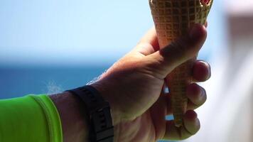 Mann Essen Eis Creme. Nahansicht Porträt von jung Hipster Mann im Sonnenbrillen Essen Eis Sahne im Sommer- heiß Wetter auf das Strand, haben Spaß und gut Stimmung. video