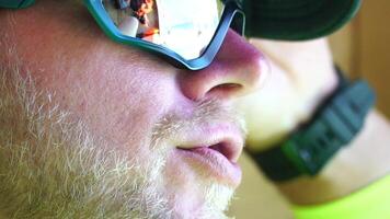 homme en mangeant la glace crème. fermer portrait de Jeune branché homme dans lunettes de soleil en mangeant la glace crème dans été chaud temps sur le plage, avoir amusement et bien ambiance. video