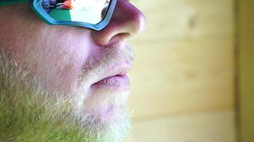 homme en mangeant la glace crème. fermer portrait de Jeune branché homme dans lunettes de soleil en mangeant la glace crème dans été chaud temps sur le plage, avoir amusement et bien ambiance. video