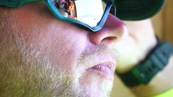 homme en mangeant la glace crème. fermer portrait de Jeune branché homme dans lunettes de soleil en mangeant la glace crème dans été chaud temps sur le plage, avoir amusement et bien ambiance. video