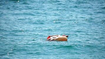 Summer Vacation man floats on an inflatable donut mattress, a water toy swim ring. Positive happy man relaxing and enjoying family summer travel holidays vacation on the sea. Slow motion video