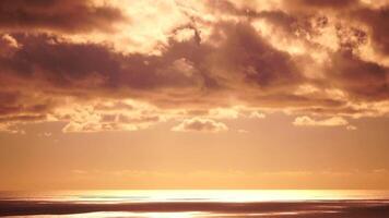 Timelapse fluffy Cumulus clouds moving in bright golden sunset sky over sea. Abstract aerial nature summer ocean sunset, sea and sky view. Vacation, travel, holiday concept. Weather and Climate Change video