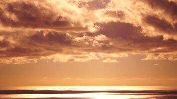 lapso de tiempo mullido cúmulo nubes Moviente en brillante dorado puesta de sol cielo terminado mar. resumen aéreo naturaleza verano Oceano atardecer, mar y cielo vista. vacaciones, viajar, fiesta concepto. clima y clima cambio video