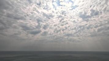 Timelapse fluffy Cumulus clouds moving in bright sunset sky over calm sea. Abstract aerial nature summer ocean sunset, sea and sky view. Vacation, travel, holiday concept. Weather and Climate Change video