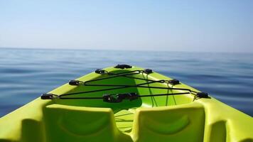 Sea water surface. Camera flies over the calm azure sea with green kayak boat on foreground. Nobody. Holiday recreation concept. Abstract nautical summer ocean nature. Slow motion. Close up video