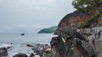 Tranquil Seascape with Solitary Boat near Rocky Shoreline photo