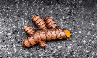 Organic Turmeric Roots on Textured Background photo