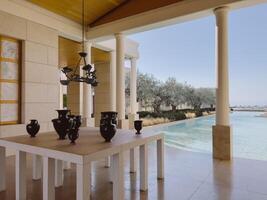 mesa con ánforas soportes en el terraza con columnas por el piscina. hotel amanzoe, Grecia foto