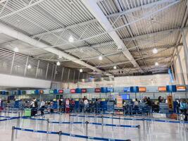 Afines, Greece - 20 august 2023. Passengers stand near check-in desks at the airport photo