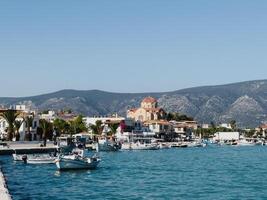 Afines, Greece - 20 august 2023. Boats are moored off the coast of the small town of Kilada at the foot of the mountains. Greece photo