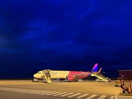 Milan, Italy - 12 november 2023. Passengers board the plane on the ramps on the runway photo