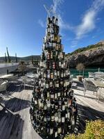 Lustica, Montenegro - 25 december 2022. Christmas tree made from wine bottles stands on the terrace of a restaurant by the sea photo