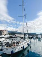 Lustica, Montenegro - 01 november 2023. Sailing yachts stand at the pier against the backdrop of a mountain range photo