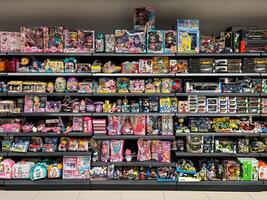 Budva, Montenegro - 01 december 2023. Multi-colored boxes with dolls, cars and constructors on the shelves in the supermarket photo